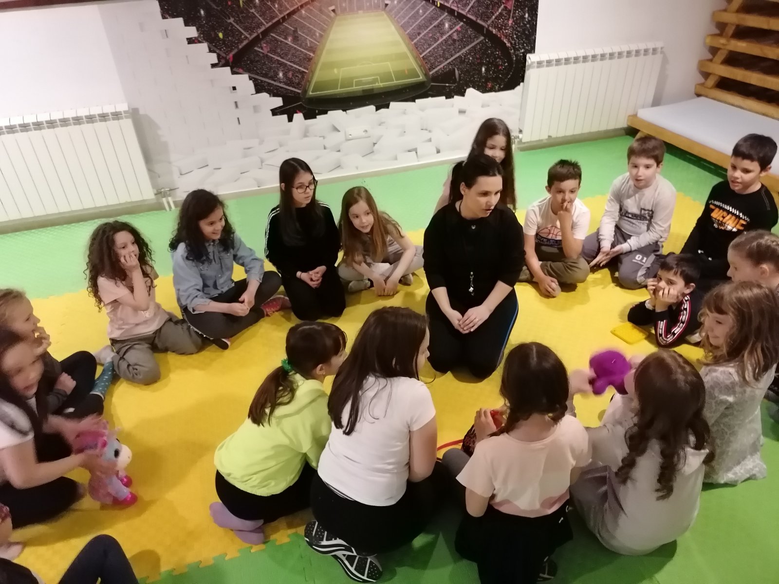 Deca u fiskulturnoj sali, okupljena oko učiteljice