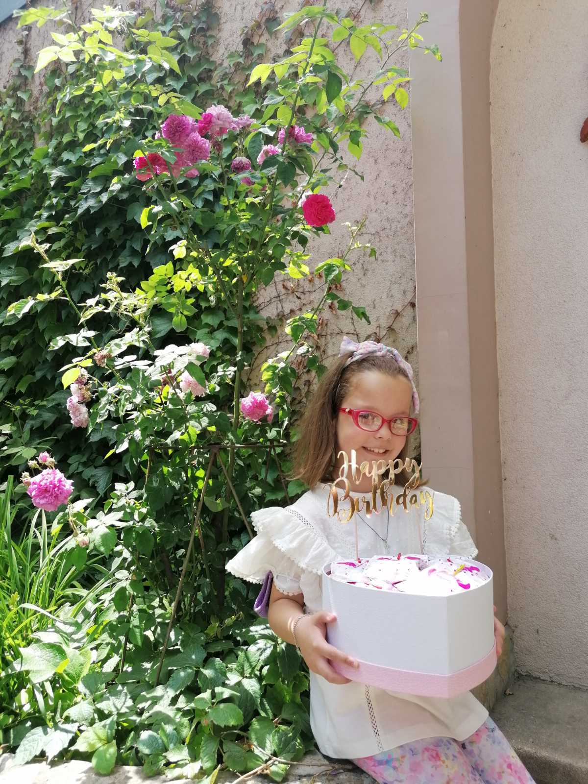 Devojčica drži tortu na proslavi svog rođendana