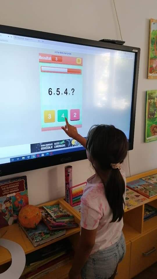 Devojčica vežba nizove brojeva na tač bordu