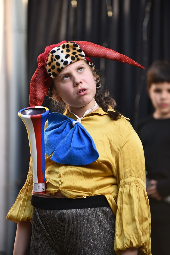 Dečak obučen u odelo dvorskog zabavljača, sa trubom za pojasom